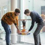 Medewerkers van het museum plaatsen voorzichtig een object voor het raam van het museum - Keramiek in quarantaine - foto Ben Nienhuis