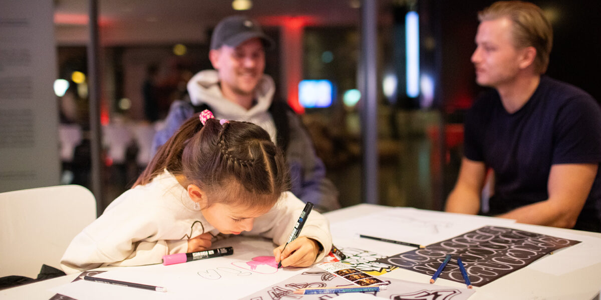 Kind zit te tekenen aan tafel.